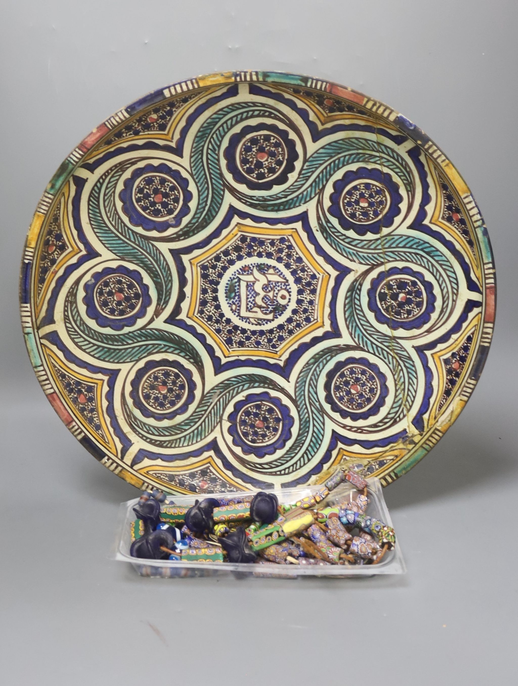 A decorative Moroccan pottery dish and a quantity of Middle Eastern glass beads and 10 turned wooden plates by P D Spear 39cm